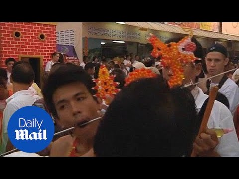 Festival goers take part in painful body piercing in Thailand - Daily Mail